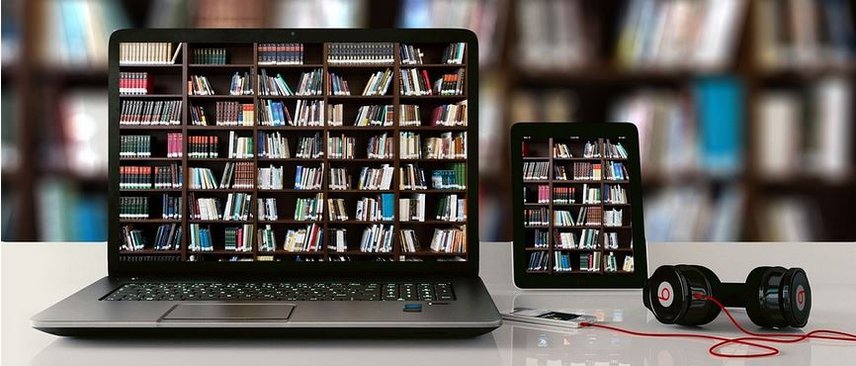 Computer und Tablet vor eine Bibliothek
